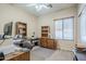 This office features wooden desk and cabinets with shelving, ceiling fan, and natural light from a window at 1813 N Lewis Pl, Casa Grande, AZ 85122