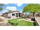 Spacious backyard oasis with artificial turf, a putting green, fire pit, and a cozy seating area at 18371 W Sunrise Dr, Goodyear, AZ 85338