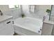 Bright bathroom featuring a white bathtub with modern marble-look tile surround at 18371 W Sunrise Dr, Goodyear, AZ 85338