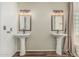 Bathroom featuring dual pedestal sinks, framed mirrors and wood laminate floors at 1898 E Kent Ave, Chandler, AZ 85225