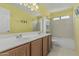Bright bathroom featuring a double sink vanity with a large mirror and a bathtub with tiled walls at 1898 E Kent Ave, Chandler, AZ 85225