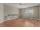 An empty bedroom with wood laminate floors, a ceiling fan, and a large window at 1898 E Kent Ave, Chandler, AZ 85225