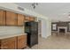 Cozy kitchen features wood cabinets, laminate countertops and black appliances with view to living room at 1898 E Kent Ave, Chandler, AZ 85225