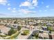 Vast aerial view of a desert neighborhood featuring orderly homes, green spaces, and clear blue skies at 22274 E Cherrywood Ct, Queen Creek, AZ 85142