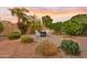 Secluded backyard with lush landscaping and a cozy patio area with seating at 22274 E Cherrywood Ct, Queen Creek, AZ 85142