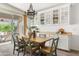 Bright dining area with wood table, stylish chandelier, and sliding door to the patio at 22274 E Cherrywood Ct, Queen Creek, AZ 85142