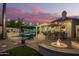 Stunning backyard with a fire pit, outdoor kitchen, pool and patio seating with pink sunset sky at 2406 E Oakland St, Chandler, AZ 85225