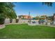 Backyard has pool, seating, BBQ, firepit, landscaped yard, and block fence perfect for outdoor entertaining and relaxing at 2406 E Oakland St, Chandler, AZ 85225