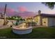 Expansive backyard featuring a fire pit and outdoor kitchen area, ideal for hosting gatherings under the stars at 2406 E Oakland St, Chandler, AZ 85225