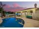 Lush backyard featuring a sparkling pool, covered patio, lounge chairs, and a barbecue grill at 2406 E Oakland St, Chandler, AZ 85225