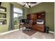 Inviting home office featuring a large desk with dual monitors, built in shelving, and an exterior view at 2406 E Oakland St, Chandler, AZ 85225