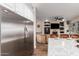 Open floor plan with a living room view showing stainless steel refrigerator, island, and fireplace at 2406 E Oakland St, Chandler, AZ 85225