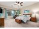Large primary bedroom with a sitting area, bay windows, wood furniture, and a ceiling fan at 2406 E Oakland St, Chandler, AZ 85225