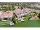 Aerial view of a home's backyard with a private dock on the lake, a covered patio, and landscaped lawn at 2454 W Hope Cir, Chandler, AZ 85248
