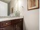 Bathroom with granite countertop, dark wood cabinets, framed mirror, and decorative accents at 2454 W Hope Cir, Chandler, AZ 85248
