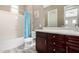 Bathroom featuring a vanity with dark wood cabinets, a white countertop, and a shower-tub combo, offering a functional space at 2454 W Hope Cir, Chandler, AZ 85248