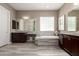 Bathroom featuring dual sinks, a soaking tub, and tile accents at 2454 W Hope Cir, Chandler, AZ 85248