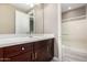 Bathroom vanity boasting dark wood cabinets, a white countertop, and a view of a shower stall, providing a clean and stylish space at 2454 W Hope Cir, Chandler, AZ 85248