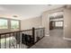 Upstairs hallway featuring neutral walls, iron railing, and views to the outside through the windows at 2454 W Hope Cir, Chandler, AZ 85248