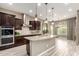 Open kitchen with island, stainless steel appliances, dark wood cabinets, and view of dining area at 2454 W Hope Cir, Chandler, AZ 85248