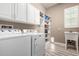 Functional laundry room with washer, dryer, sink, white cabinets and shelving at 2454 W Hope Cir, Chandler, AZ 85248