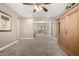 Spacious living room with neutral walls, ceiling fan, light carpet, and a decorative armoire at 2454 W Hope Cir, Chandler, AZ 85248