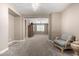 Bright, carpeted living room showcasing neutral paint, a ceiling fan, and a comfortable upholstered armchair at 2454 W Hope Cir, Chandler, AZ 85248