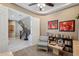 A home office with art on the walls and a doorway to a staircase with a wrought iron banister at 2454 W Hope Cir, Chandler, AZ 85248