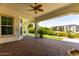 Covered patio featuring brick flooring, supported by pillars, overlooking landscaped grounds, creating a relaxing outdoor space at 2454 W Hope Cir, Chandler, AZ 85248