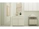 Well-lit laundry room with cabinets, laundry cart and decorative wall art at 25162 N 177Th Dr, Surprise, AZ 85387