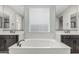 This primary bathroom boasts a large soaking tub, dual sink vanities, and lots of natural light at 2557 N Springfield St, Buckeye, AZ 85396