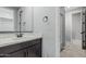 Bathroom featuring a dark wood vanity, framed mirror, and doorway to glass enclosed shower at 2557 N Springfield St, Buckeye, AZ 85396
