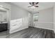 Bedroom with wood flooring, neutral colors, a ceiling fan and an open bathroom at 2557 N Springfield St, Buckeye, AZ 85396