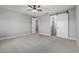 Bedroom with neutral carpet, barn door to the bathroom, and standard door to hallway at 2557 N Springfield St, Buckeye, AZ 85396