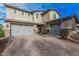 Beautiful home featuring a large driveway leading to a two-car garage, set against a blue sky at 2557 N Springfield St, Buckeye, AZ 85396