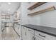 Modern kitchen with subway tile backsplash, floating shelves, and stainless steel appliances at 2557 N Springfield St, Buckeye, AZ 85396