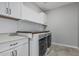 Bright laundry room features modern washer and dryer with counterspace and white cabinets at 2557 N Springfield St, Buckeye, AZ 85396