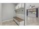 Mudroom features a built-in bench with storage, hooks, and an overhead cabinet, with view to living room at 2557 N Springfield St, Buckeye, AZ 85396