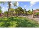 Spacious backyard features a lush lawn, mature trees, beautiful landscaping, and a pool with safety fencing at 285 W Goldfinch Way, Chandler, AZ 85286