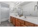 Bright bathroom featuring double sinks with wooden cabinets and a walk-in shower at 285 W Goldfinch Way, Chandler, AZ 85286