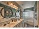 Bathroom featuring double vanity sinks, decorative mirrors and a separate shower with glass door enclosure at 29023 N 46Th Way, Cave Creek, AZ 85331