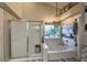 Bright bathroom with a soaking tub, tiled shower, and decorative chandelier at 29023 N 46Th Way, Cave Creek, AZ 85331