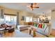 Bright living room featuring a large sectional sofa, ceiling fan, and view to the backyard at 29023 N 46Th Way, Cave Creek, AZ 85331