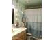 Bright bathroom with a single sink vanity, shower-tub combo with curtain, and blue-green walls at 3001 W Shaw Butte Dr, Phoenix, AZ 85029