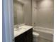 Bathroom featuring a dark vanity, white countertop, and a shower-tub combo with white tiled wall at 31619 N Shady Pasture Ln, San Tan Valley, AZ 85143