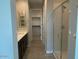 Bathroom featuring modern glass enclosed shower, vanity, and access to the walk-in closet at 31619 N Shady Pasture Ln, San Tan Valley, AZ 85143