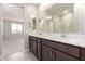 Modern bathroom featuring double sinks, dark cabinetry, and an open-concept design at 31619 N Shady Pasture Ln, San Tan Valley, AZ 85143