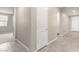 Well-lit hallway with tile floors, neutral paint, and a series of white doors, creating a clean and modern aesthetic at 31619 N Shady Pasture Ln, San Tan Valley, AZ 85143