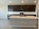 Modern kitchen featuring sleek dark cabinets, subway tile backsplash, and a large island perfect for entertaining at 31619 N Shady Pasture Ln, San Tan Valley, AZ 85143