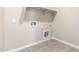 Spacious laundry room with grey floors, utility hookups, and ample shelving perfect for organization at 31619 N Shady Pasture Ln, San Tan Valley, AZ 85143